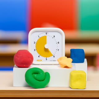 The Time Timer MOD Education Edition 10 Minute timer is shown next to some play dough shapes in colorful classroom setting.